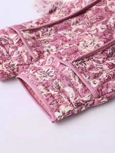 Close-up of quilted floral cotton jacket with purple piping and vintage flower print