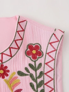 Close-up of intricate floral embroidery and geometric patterns on a pink Y2K vest top