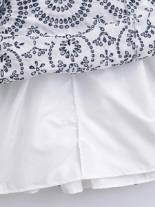 White eyelet sleeveless V-neck dress with navy blue floral embroidery and soft inner lining