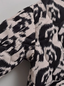 Gros plan d'une veste matelassée en coton avec imprimé animal et surpiqûres
