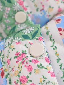 Close-up of floral quilted jacket featuring resin buttons and soft diamond texture