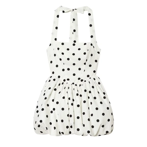 Detail of white halter neck dress with black polka dots and tiered bubble hemline