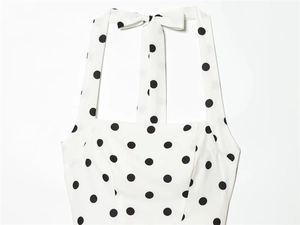 Detailed close-up of halter neckline with polka dot print and bow-tie ribbon fastening