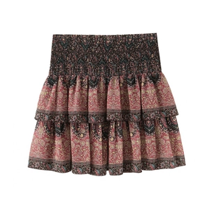 Detail view of smocked waist and bohemian floral pattern on layered ruffle skirt