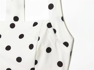 Detail of square neckline and wide straps on white polka dot dress with neat stitching