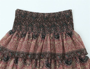 Detail view of the smocked elastic waist and ruffled layers on paisley floral skirt