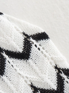 Macro detail of black and white wavy crochet knit fabric with hollow pointelle texture