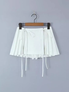White high-waisted pleated mini skirt with side zippers and decorative streamers