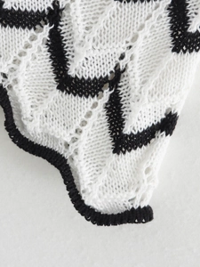 Detailed macro view of black and white chevron crochet knit fabric on a slim dress