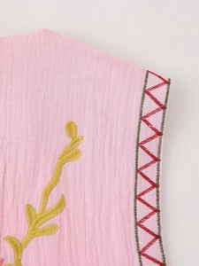Close-up of pink Y2K vest featuring yellow leaf embroidery and wavy patterned stitching