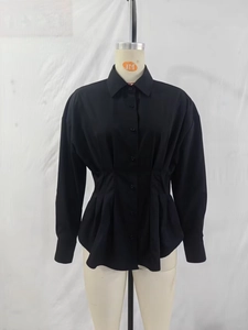 Détails des plis à la taille et fermeture boutonnée de ce chemisier noir à manches longues