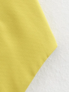 Close-up of yellow twill woven fabric showing detailed mustard texture and fiber pattern