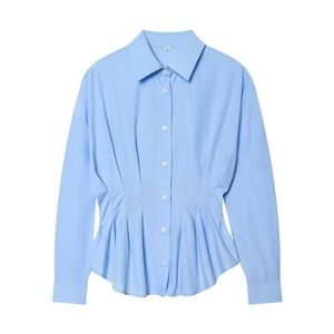 Détail d'une chemise bleu clair à manches longues avec col à revers et plis