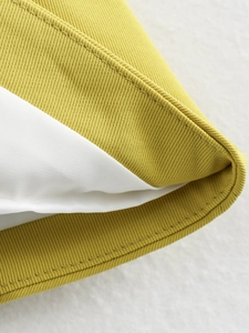Detailed close-up of yellow twill fabric vest with neat stitching and smooth white lining