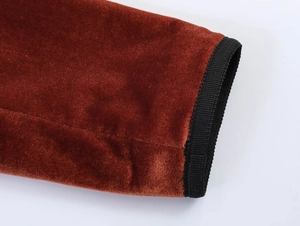 Close-up of caramel velvet blazer sleeve with black ribbed cuffs and premium stitching