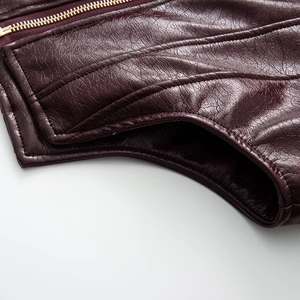 Macro detail of wine red faux leather jacket with gold zipper and precision double stitching