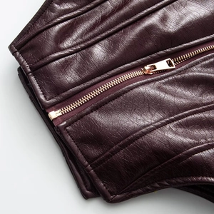 Detailed macro view of dark burgundy faux leather with quilted stitching and gold zipper