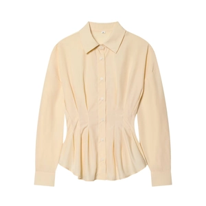 Détail des plis à la taille et de la fermeture boutonnée de cette chemise abricot