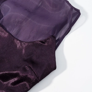 Détail du mesh violet et du tissu texturé métallique de la robe en gros plan