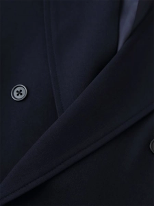 Close-up of premium twill fabric texture and buttons on a navy blue tailored blazer