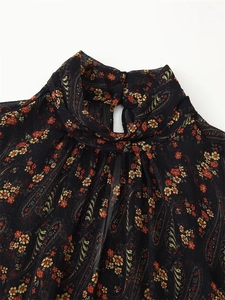 Detail of high ruffled neck and paisley floral print on black chiffon dress fabric