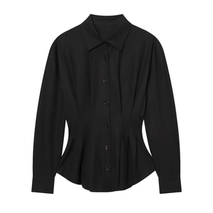 Vue détaillée de la taille plissée et de la texture du tissu d'une chemise noire à manches longues