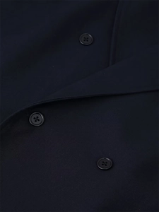 Macro shot of three black resin buttons on navy blue textured woven blazer fabric