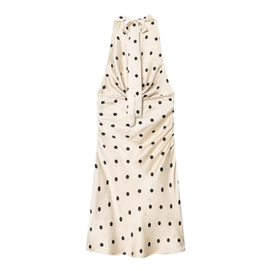 Detail of champagne satin halter dress featuring black polka dots and sleek backless design
