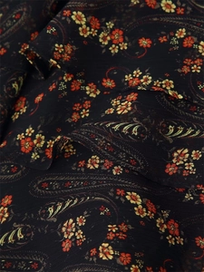 Macro detail of lightweight black chiffon fabric featuring vintage floral paisley patterns