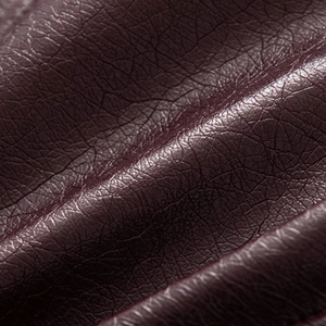 Macro shot of high-quality dark burgundy faux leather featuring a classic pebble grain texture