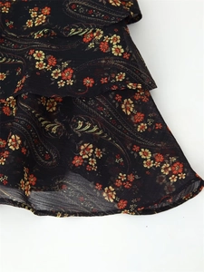 Detail of floral paisley print on black chiffon fabric with layered ruffle design