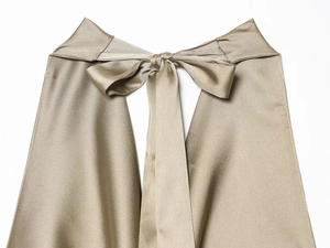 Detail of champagne satin dress showing elegant back halter neckline with bow tie design