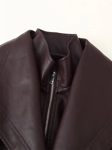 Detailed macro view of burgundy faux leather jacket lapel and silver metal zipper teeth