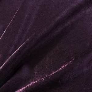 Vue macro du tissu satiné plissé violet foncé avec un éclat et une texture élégants