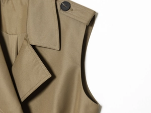 Gros plan du gilet kaki à épaulettes avec tissu sergé et détails de boutons noirs