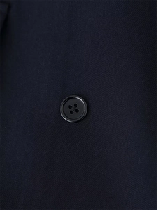 Detail of premium textured fabric and black four-hole button on the elegant blazer