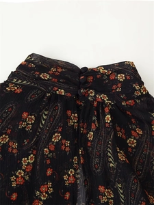 Detailed close-up of high-neck floral blouse with paisley print and back button closure