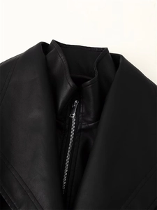 Close-up of black faux leather jacket featuring a silver metal zipper and stand collar