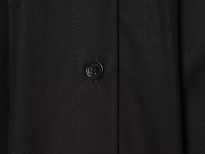 Détail macro du tissu noir de haute qualité avec texture horizontale et bouton à 4 trous