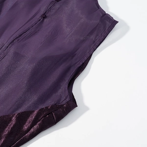 Détail du patchwork en résille violet foncé et velours avec un bouton sur le col