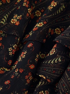 Detail of floral paisley chiffon fabric with multi-layered ruffle edges and soft pleats
