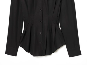 Détail d'une chemise noire à manches longues avec plis à la taille et boutons à boutonnage simple