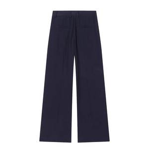 Detail of high-waisted dark blue wide-leg suit trousers with sharp front creases
