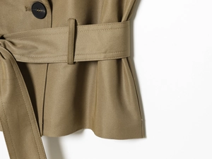 Détail du gilet en sergé kaki montrant la ceinture, la double couture et le bouton