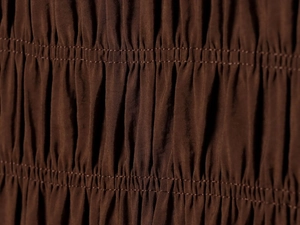 Macro detail of elastic shirring and parallel stitching on brown midi dress fabric