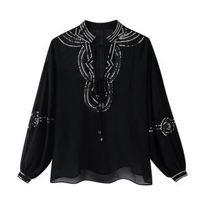 Detailed view of silver sequins and beadwork on a black V-neck chiffon blouse sleeve
