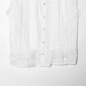 White sleeveless cotton shirt with vertical pleats and intricate floral lace embroidery
