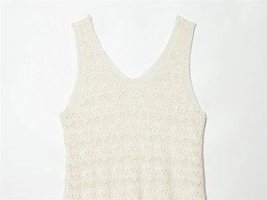 Detail of V-neck sleeveless knitted dress featuring intricate hollow wave patterns