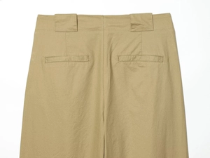 Détail du pantalon plissé kaki montrant de larges passants et des poches passepoilées au dos