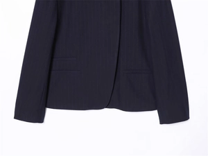 Detail view of navy blue pinstripe blazer featuring refined texture and double-welt pocket